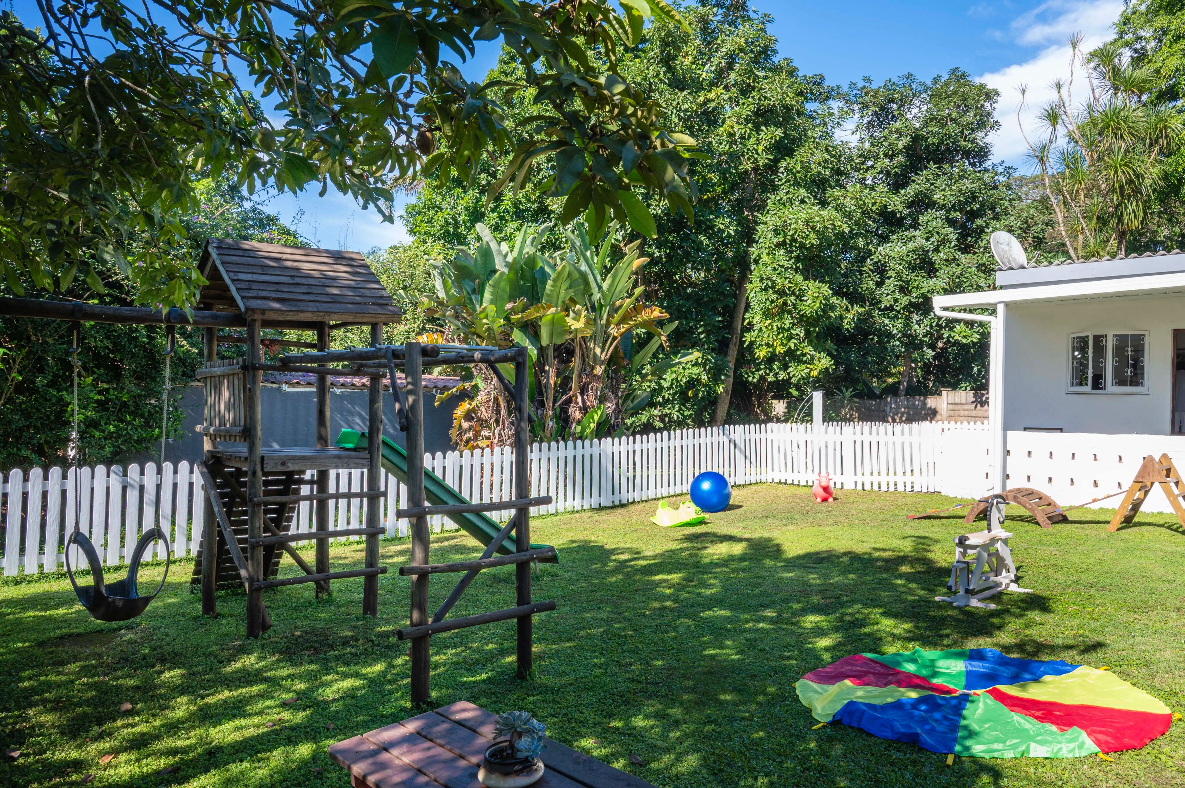 Jungle gym, swings and parachute on the grass