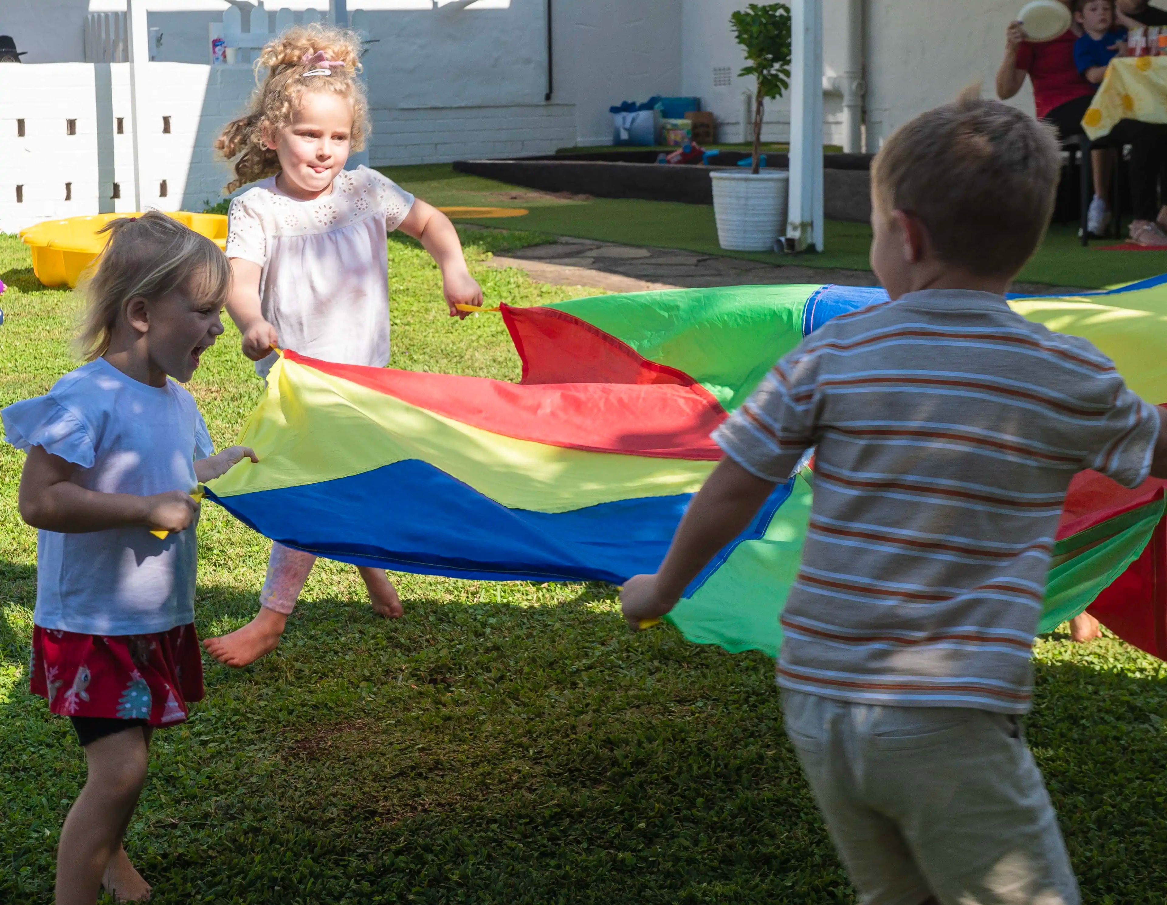 Kids playing with rainbow parachute